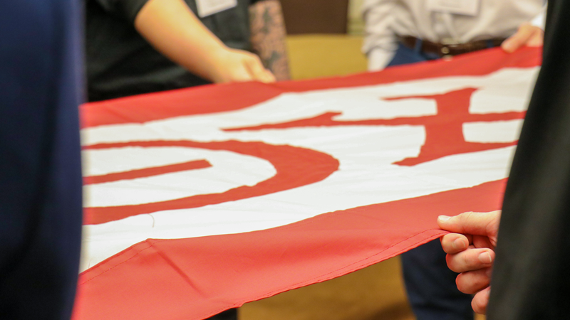 Theta Chi banner behind held by a group